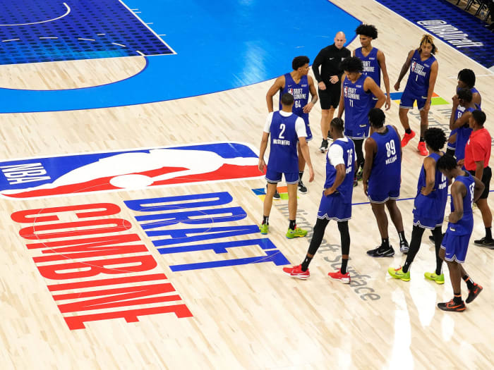Players stand next to the NBA draft combine logo